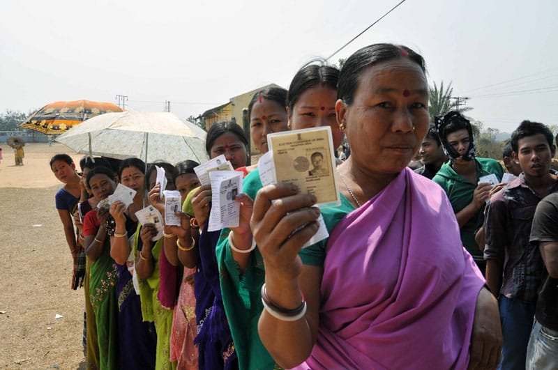 The women voters standing in a queue showing their Election Photo Identity Cards...
