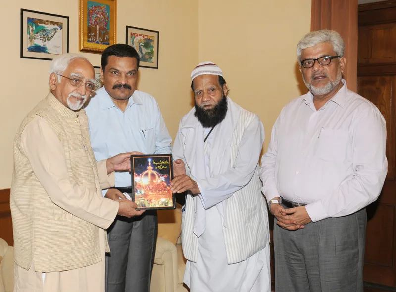 The Vice President, Shri Mohd. Hamid Ansari being presented a book on...