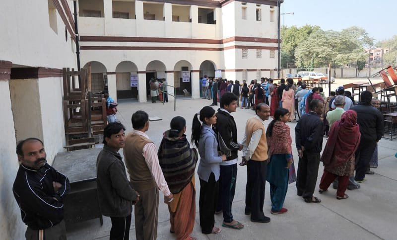A long queue of voters to cast their vote for Delhi Assembly Election, at a polling booth, in New Delhi