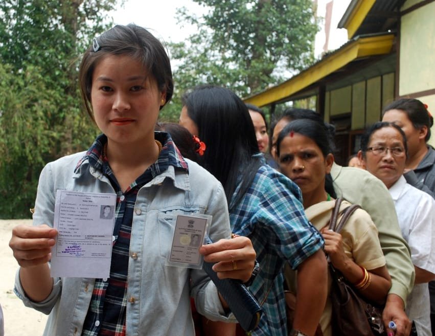 A first time female voter displaying her voter identity card, at a polling booth…