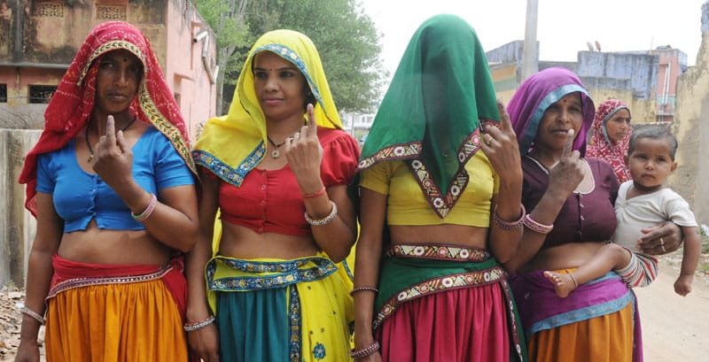Rural women voters showing mark of indelible ink after casting their votes,…