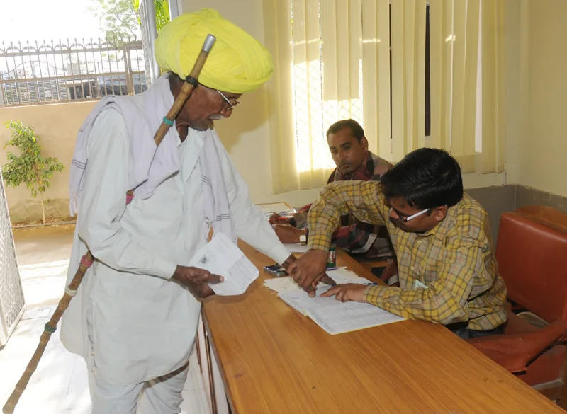 An elderly voter being registered his name to cast his vote, at a polling…