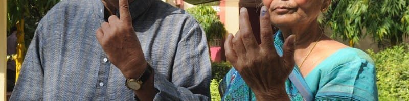 An elderly couple voters showing mark of indelible ink after casting their votes,...