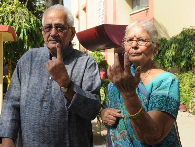 An elderly couple voters showing mark of indelible ink after casting their votes,…