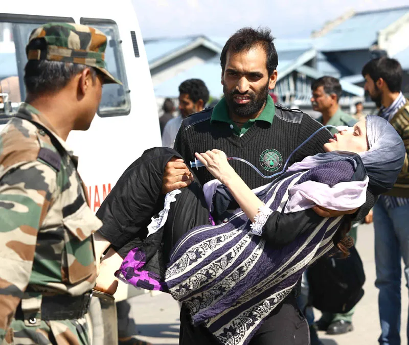An ailing woman being carried for emergency medical aid in an armed forces medical camp in Jammu & Kashmir