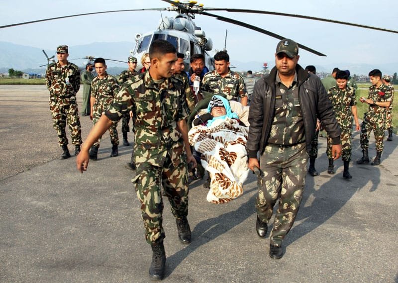 The Indian Air Force (IAF) and Nepal army personnel helping a stranded woman..
