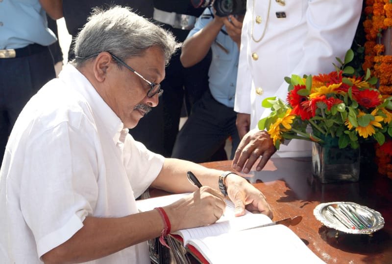 The Union Minister for Defence, Shri Manohar Parrikar signing the visitor’s book after ..
