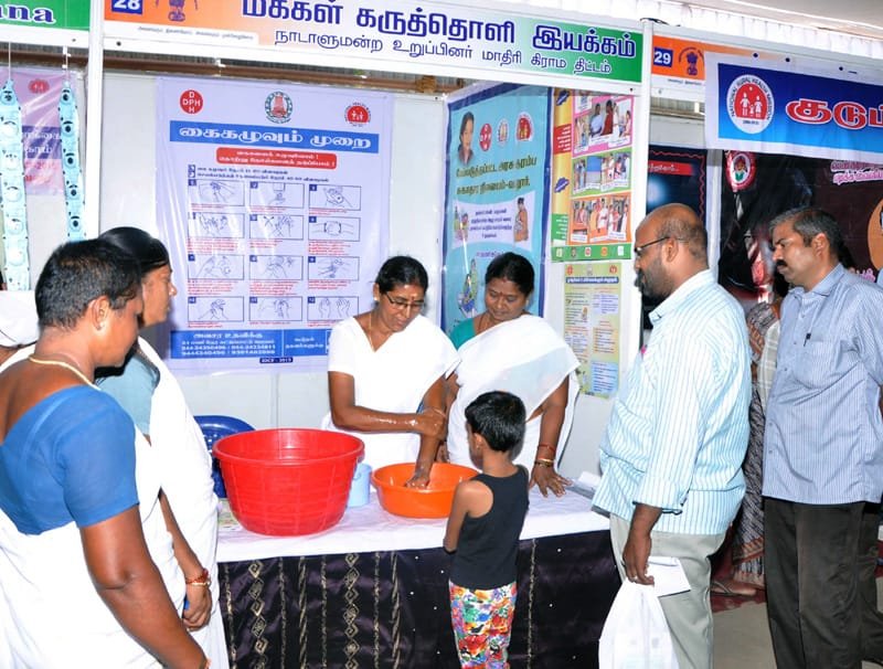 A young girl being shown the technique of proper hand wash at a stall, by the ..