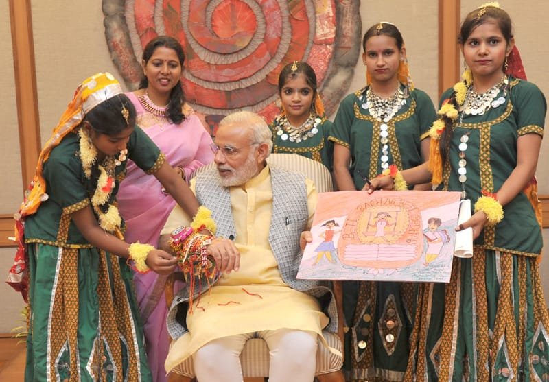 Women and Children from various segments of society tying ‘Rakhi’ on the Prime Minister,..