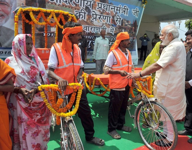 The Prime Minister, Shri Narendra Modi interacting with the beneficiaries of E-Rickshaw and..
