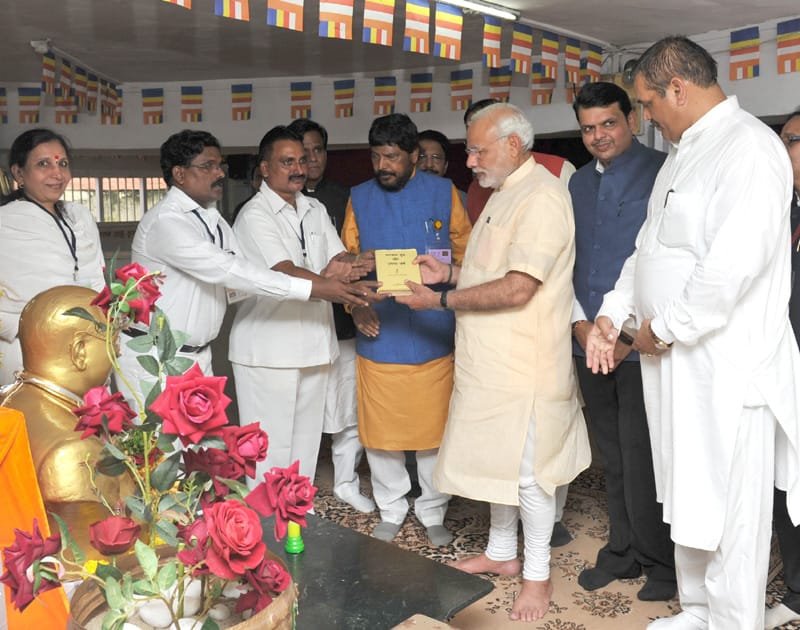 The Prime Minister, Shri Narendra Modi being presented a book “Bhagwan Budh or..