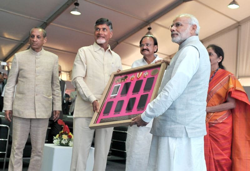 The Prime Minister, Shri Narendra Modi being presented a memento by the Chief Minister of ..
