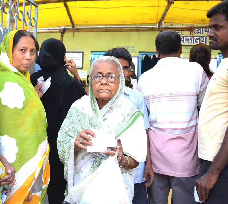 An elderly woman voter displaying identity card after cast her vote, at a polling booth,..