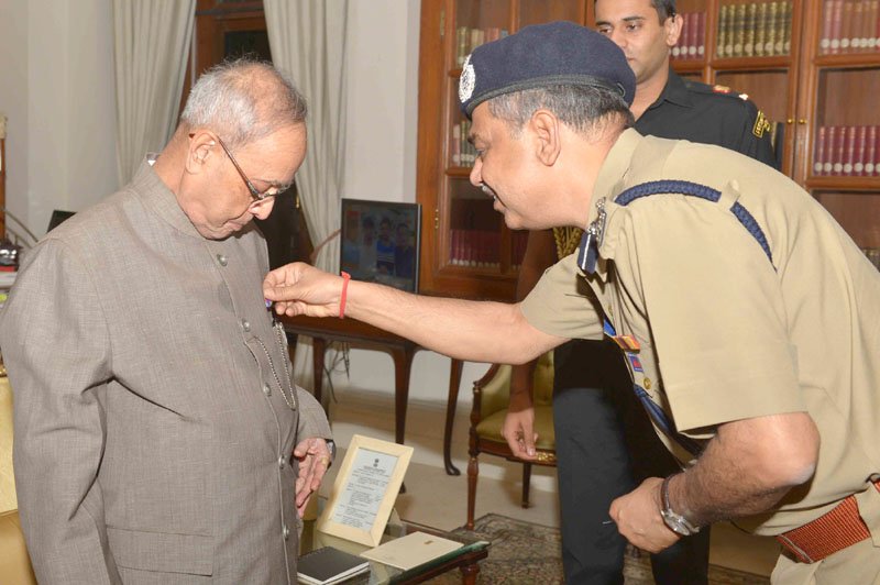 The Director-Delhi Fire Services, Shri G.C. Mishra pinning a Flag on the President,..