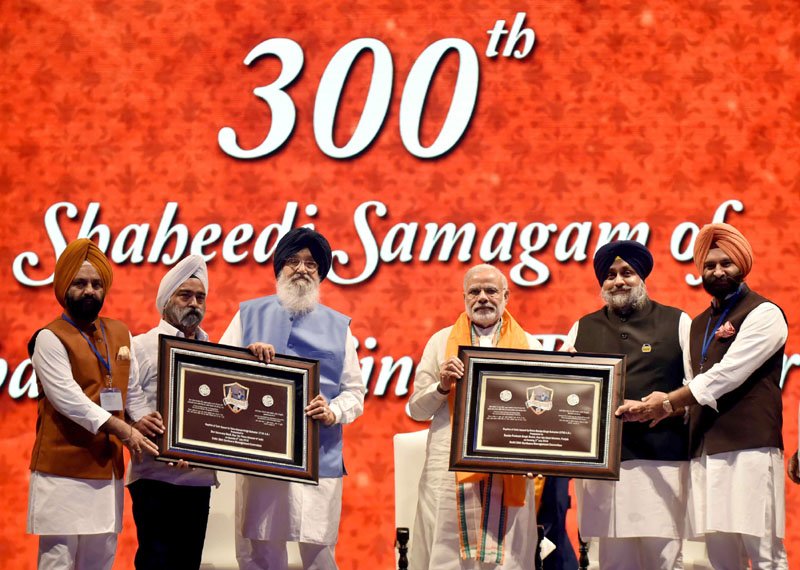 The Prime Minister, Shri Narendra Modi being presented with recently released..