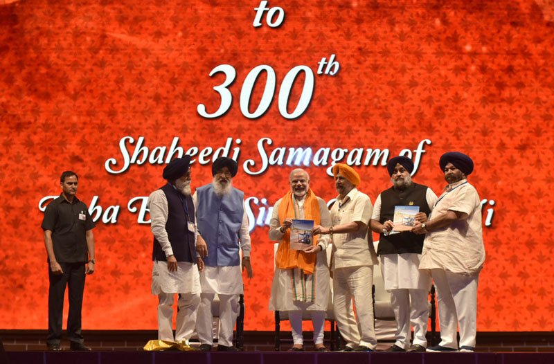 The Prime Minister, Shri Narendra Modi being welcomed on stage at the 300th Martyrdom ..