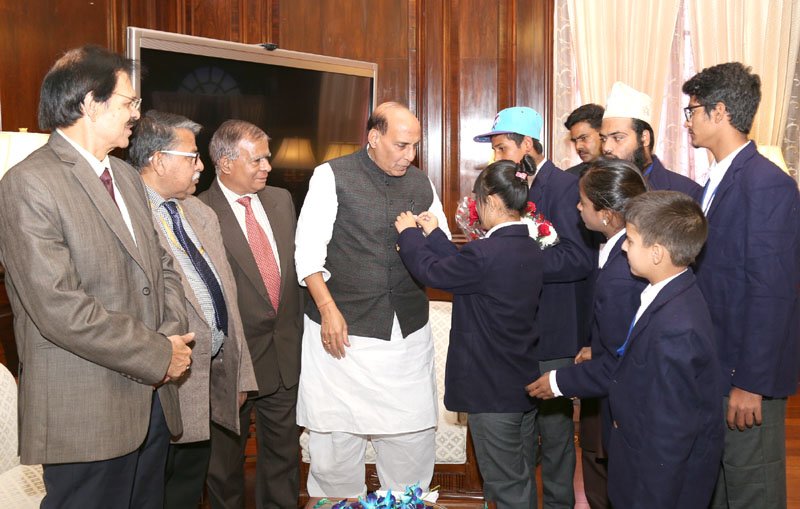 A group of children pinning flag on the Union Home Minister, Shri Rajnath Singh, as part of the Communal Harmony Campaign Week, in New Delhi