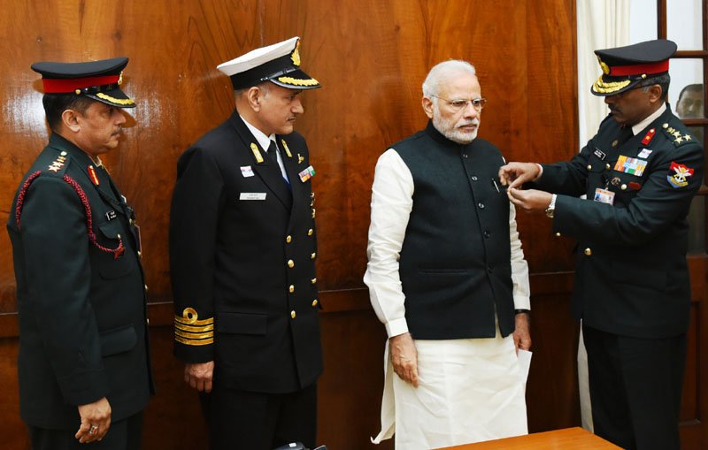 The Officers of the Kendriya Sainik Board pinning a flag on the Prime Minister, ..